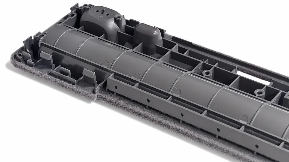 ABS automotive interior component with molded structure and flocked edges.