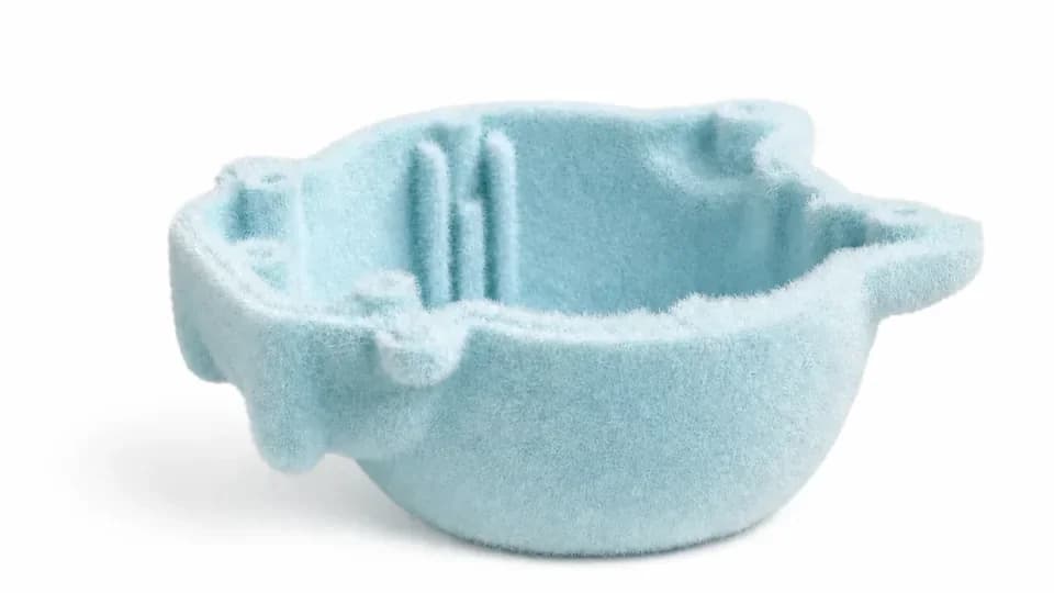 Light-blue flocked photosensitive resin prototype on a white background.