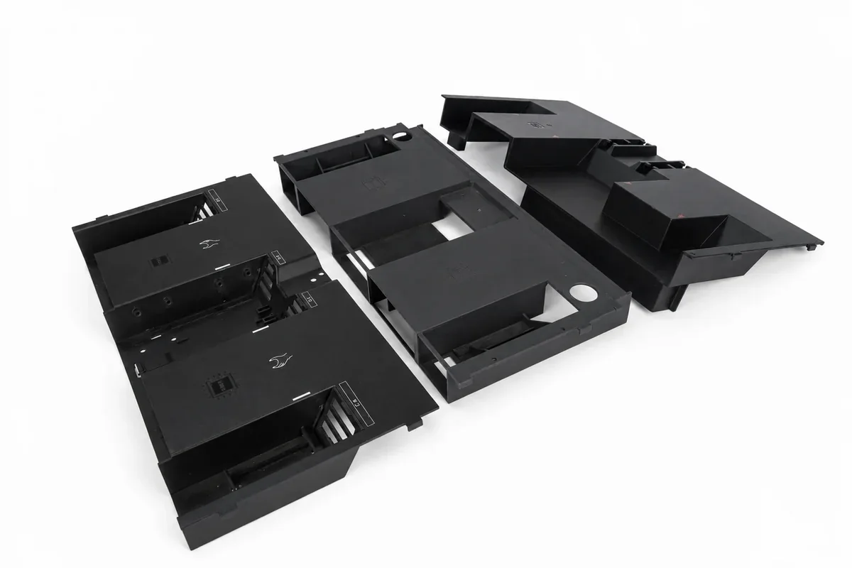 Grouped black vacuum-cast housings on a white background